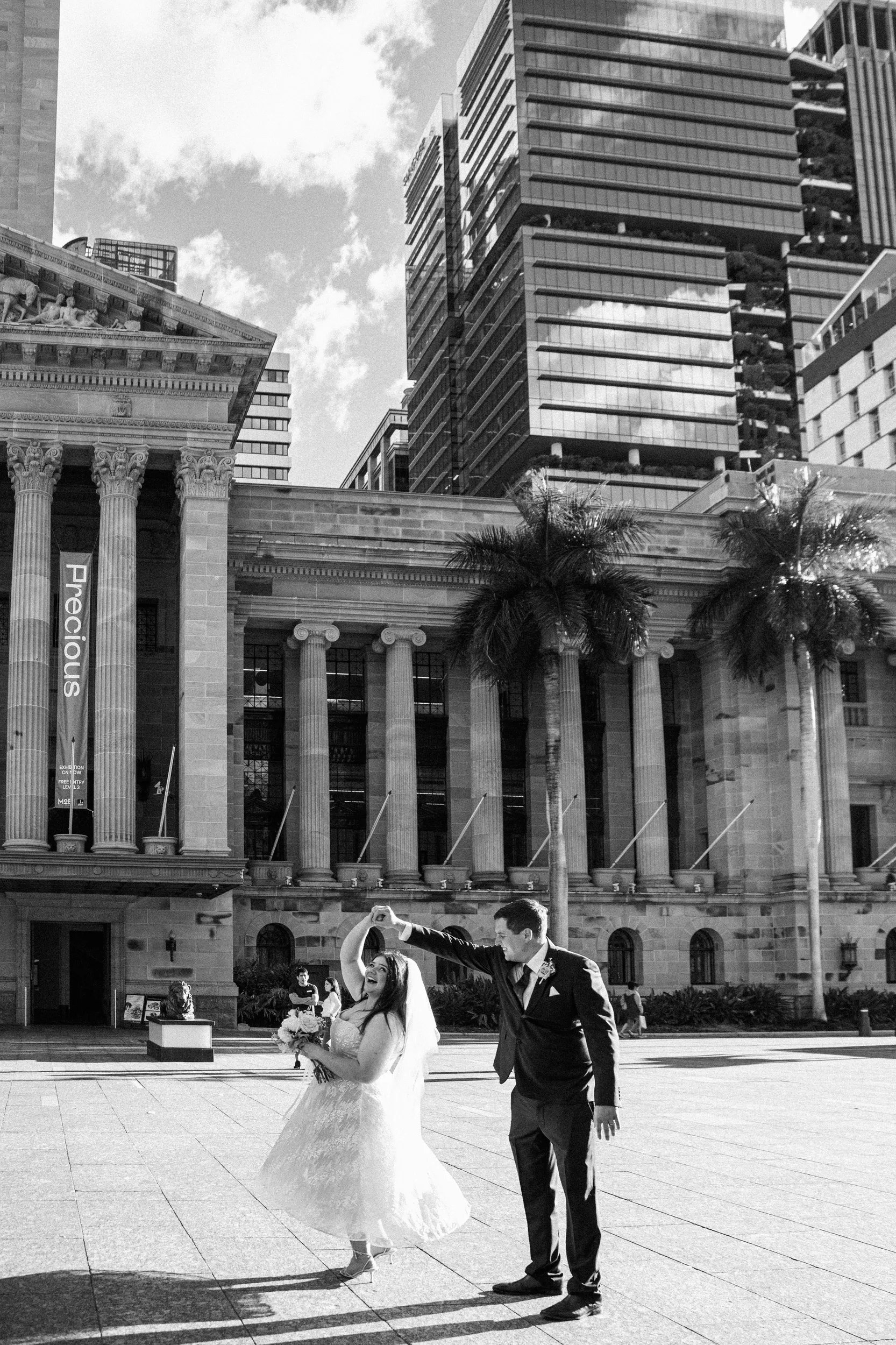 Carlie and Iain dramatic black and white portrait in front of classical building with modern skyscrapers backdrop