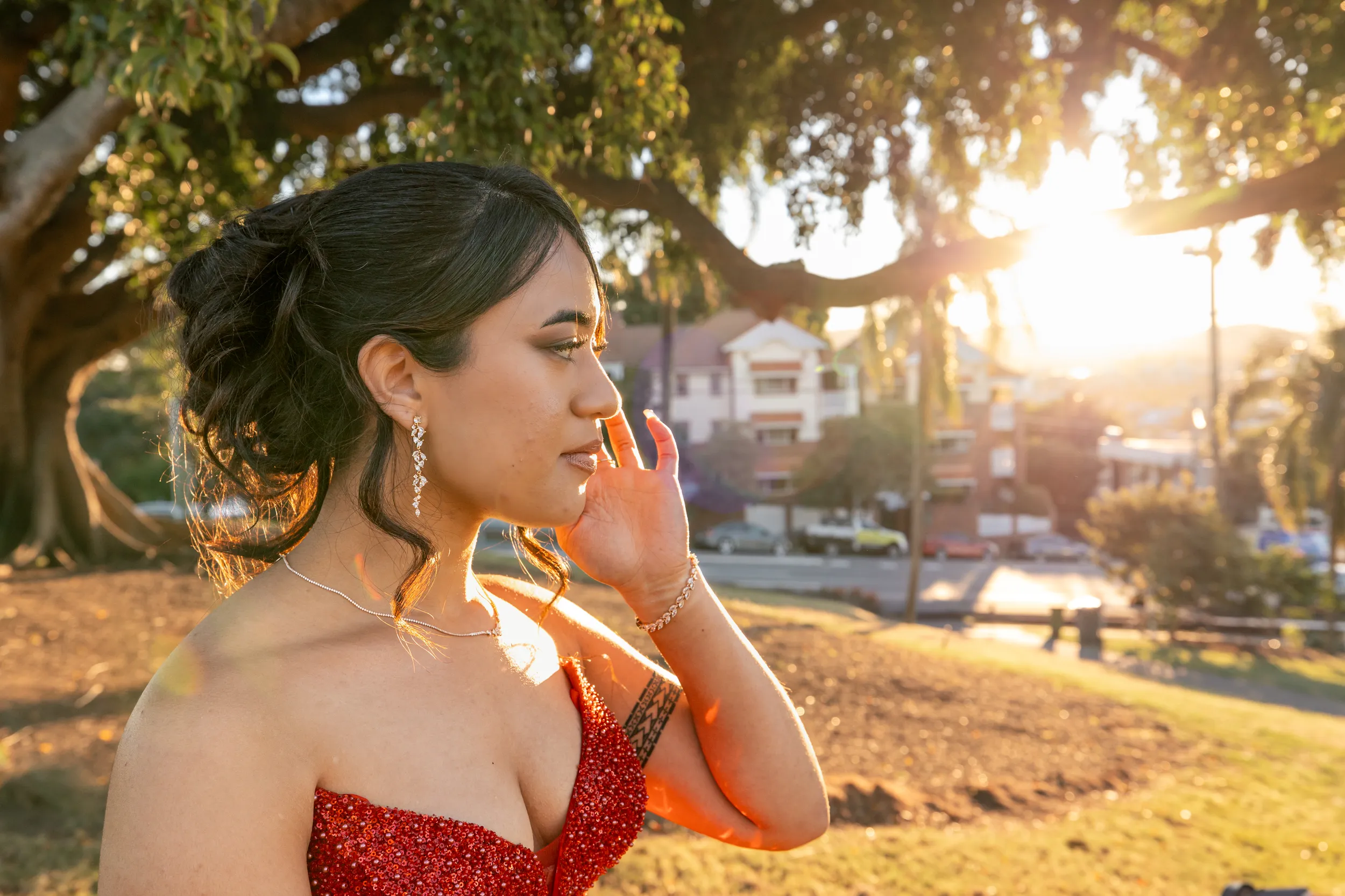 Beautiful profile portrait with golden hour lighting and lens flares in red sparkly dress