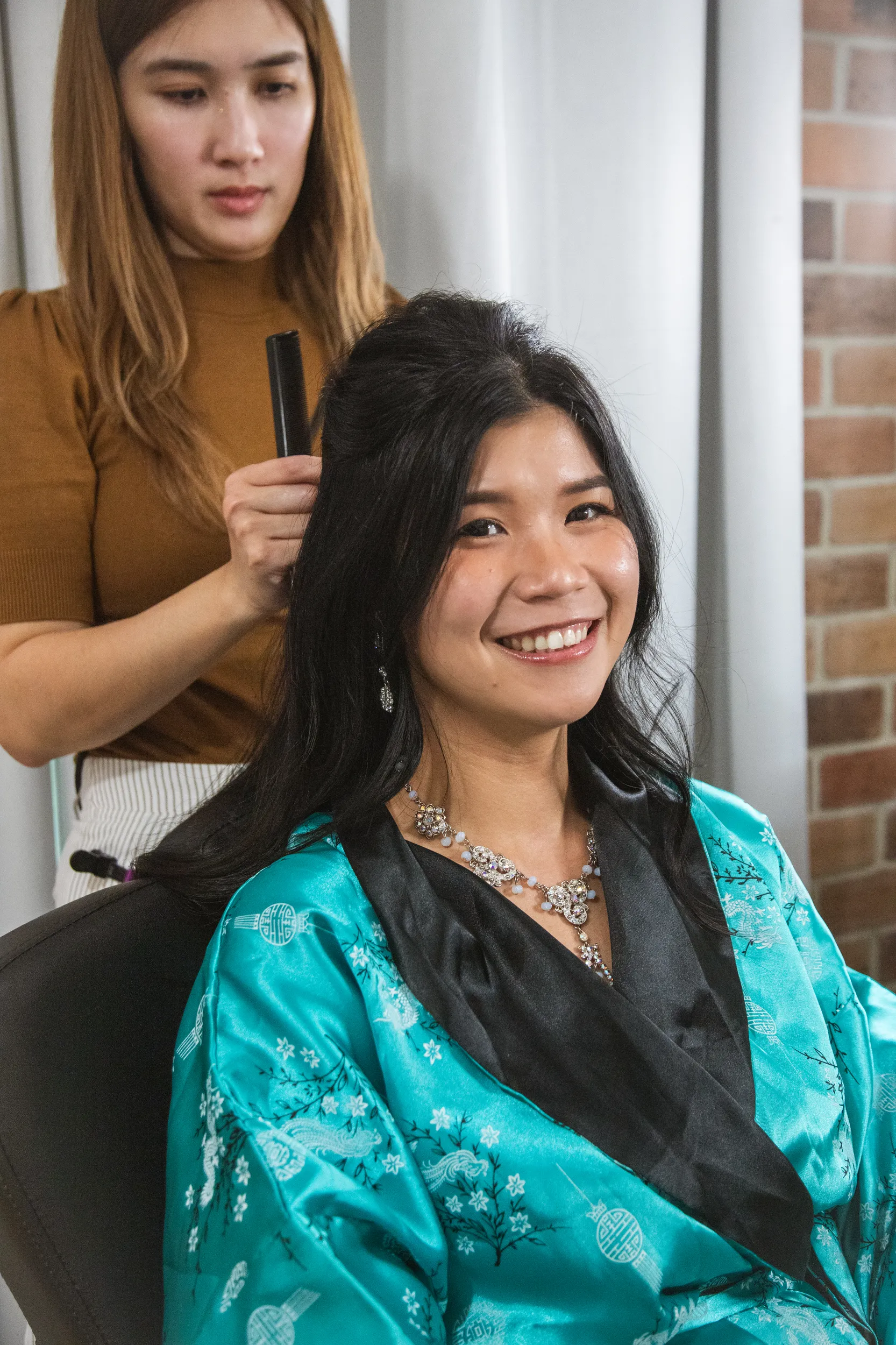 Huiyu getting ready in beautiful turquoise silk robe with crystal statement necklace and radiant smile