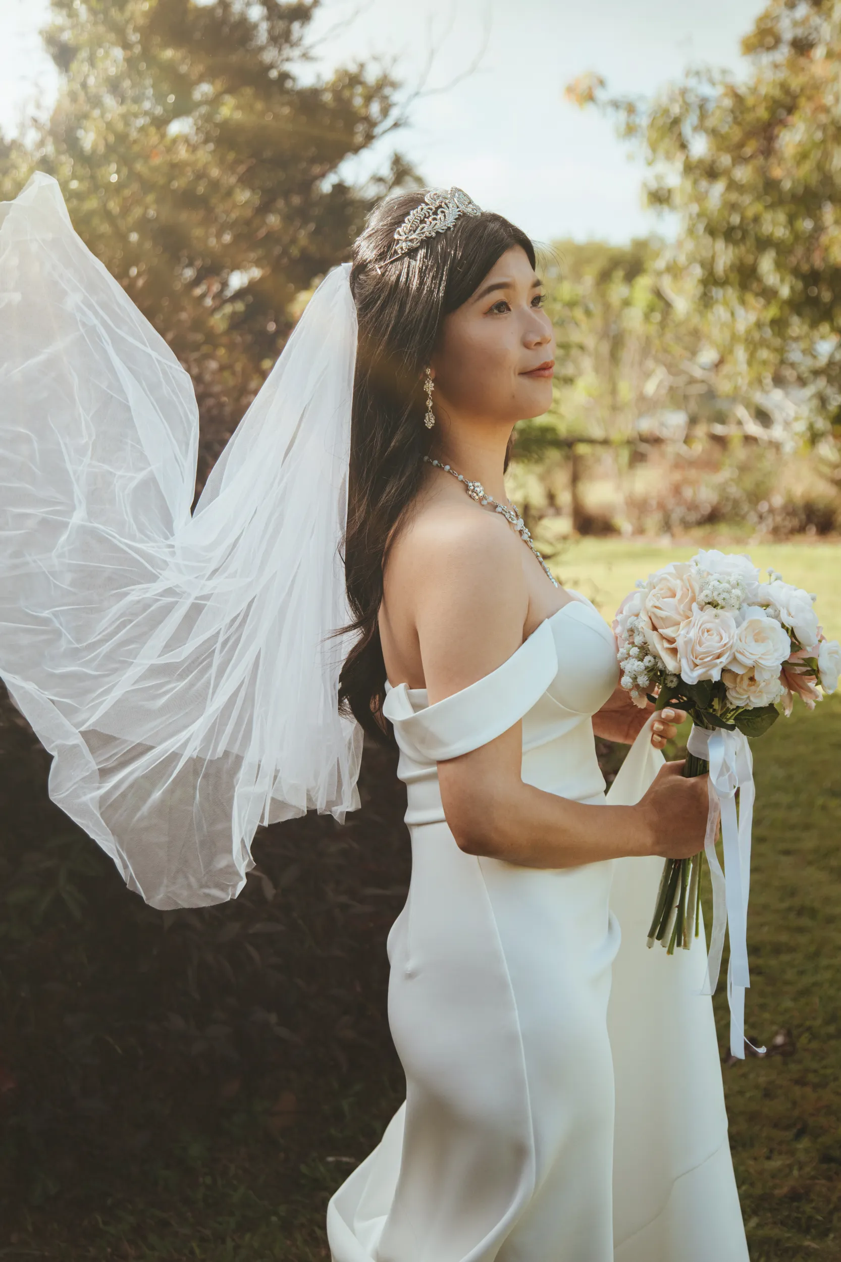 Huiyu dreamy golden hour bridal portrait with flowing veil crystal tiara and rose bouquet