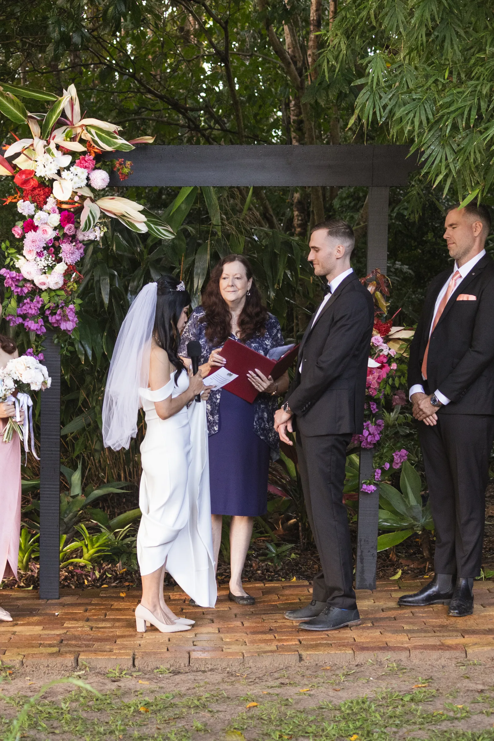 Huiyu and Chris wedding ceremony wide shot under decorated pergola with family and officiant present