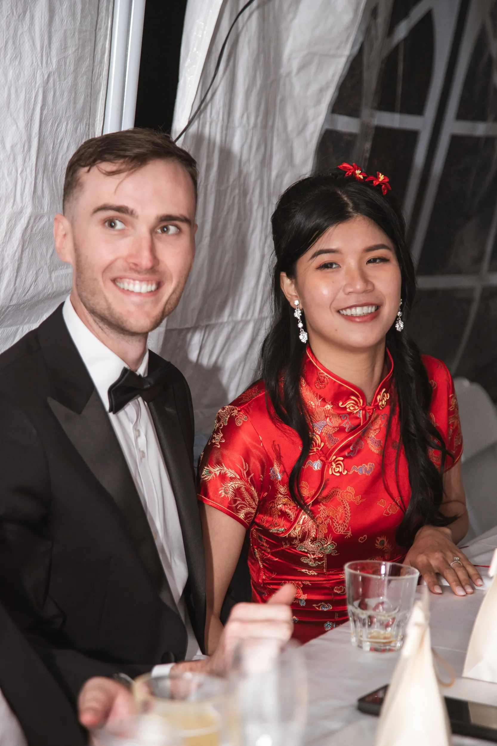 Huiyu and Chris reception portrait with bride in red traditional Chinese qipao dress and groom in tuxedo