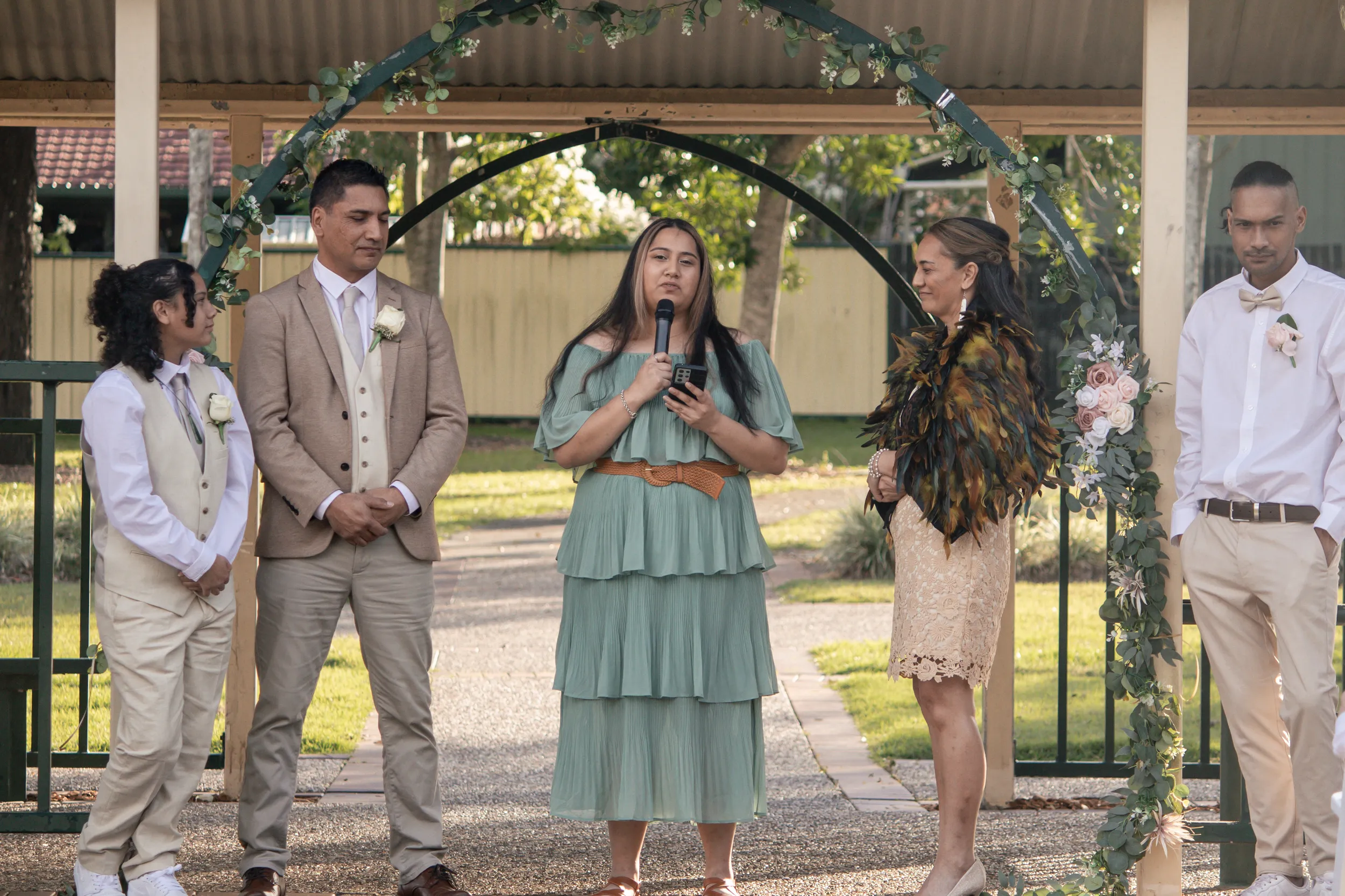 Cultural wedding ceremony under pavilion with bride in traditional dress, officiant, and wedding party